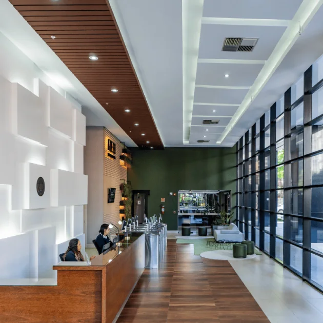 Recepção do edifício, com balcão de atendimento e pé-direito alto